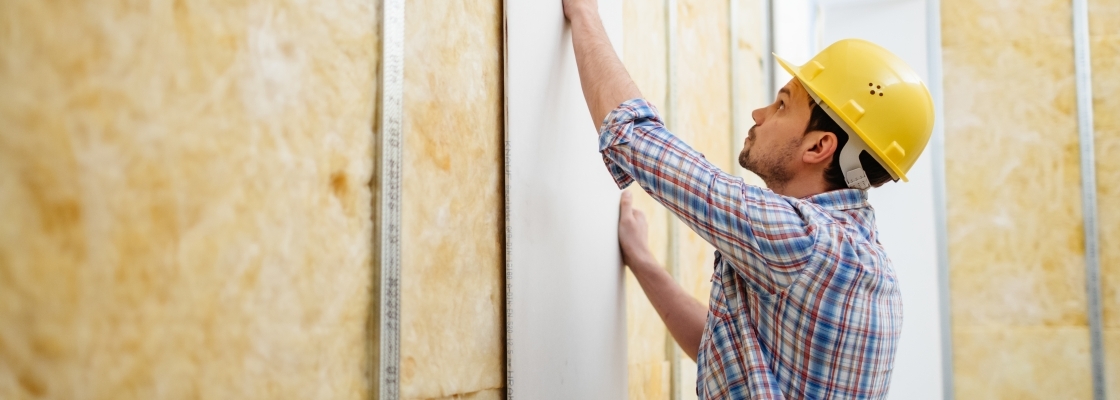 A home builder putting up drywall 