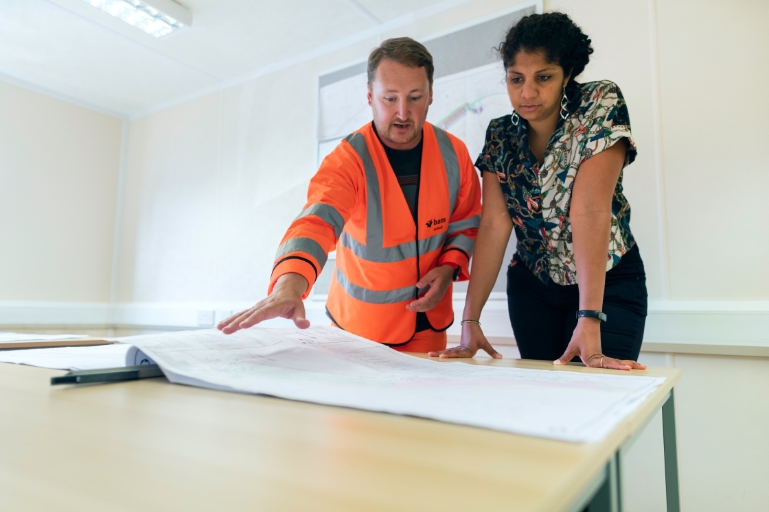 Two people looking at engineering blueprint